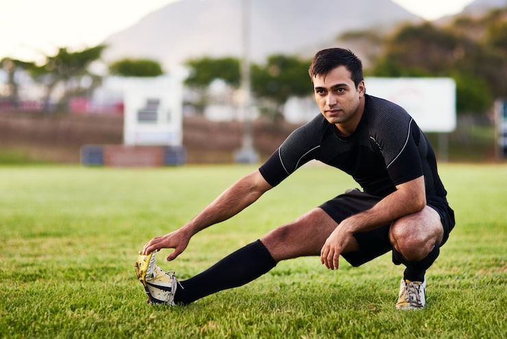 Bild sport rugby och spelare som stretchar för kondition på gräsplan med matchuppvärmningsspel träning och prestation idrottare man och benövning för tävlingsförberedelse och träning för turnering