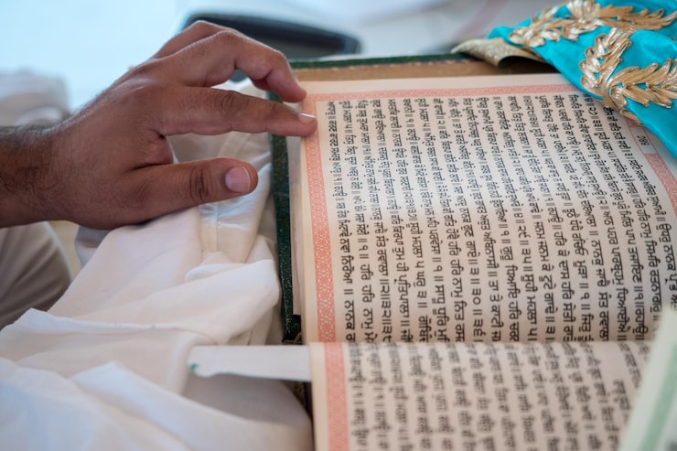 Fotoğraf geleneksel bir hint düğününde granth sahib'i okuyan bir adamın yakın çekimi