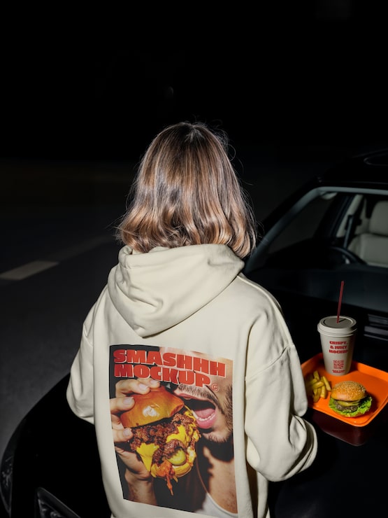 PSD gratuito persona con capucha disfrutando de comida rápida por su coche por la noche