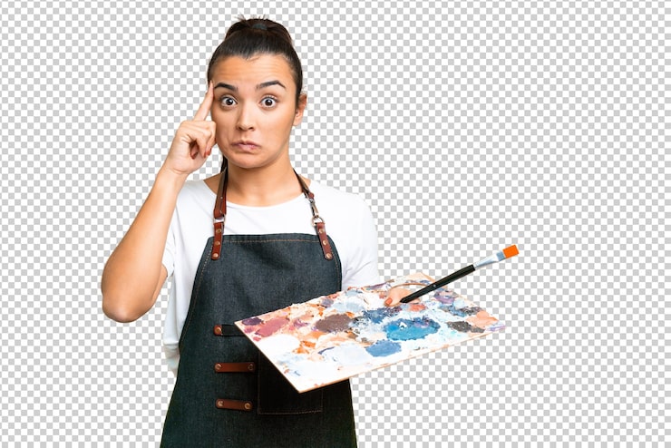 PSD mujer joven artista sosteniendo una paleta sobre un fondo clave de croma aislado pensando en una idea