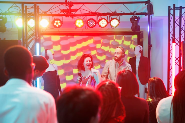 Ücretsiz Fotoğraf kulüpte dans partisinde kalabalık kulüpleşirken şarkıcı ve dj grubu sahnede performans sergiliyor. gece kulübünde elektronik müzik festivalinde müzisyenler çalarken insanlar dans pistinde eğleniyor