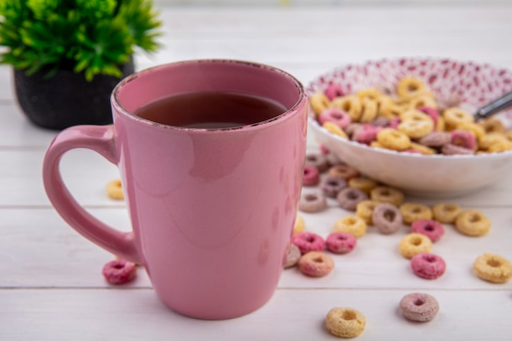 Ücretsiz Fotoğraf önden görünüş, beyaz yüzey üzerinde kasede tahıllarla birlikte pembe çay fincanı