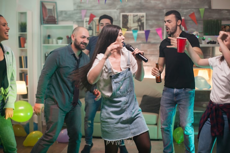 Ücretsiz Fotoğraf partide arkadaşları için karaoke yapan, mutluluk dolu güzel genç kadın.