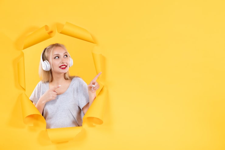 Ücretsiz Fotoğraf yırtık sarı kağıt arka planında kulaklıklı genç kadın, ses ultrasonu müzik ses