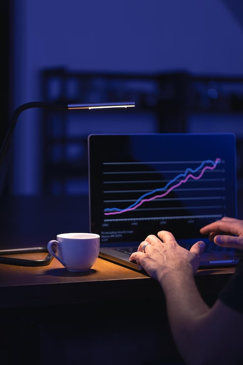Gratis Foto broker kijkt naar laptop analyseert aandelenmarkt investeren handel aandelen grafiek