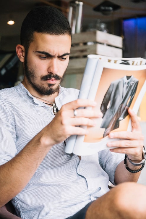 Gratis Foto ernstige man geconcentreerd op tijdschrift