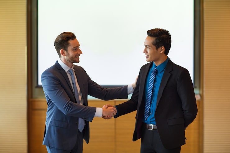 Gratis Foto glimlachende business leader greeting partner