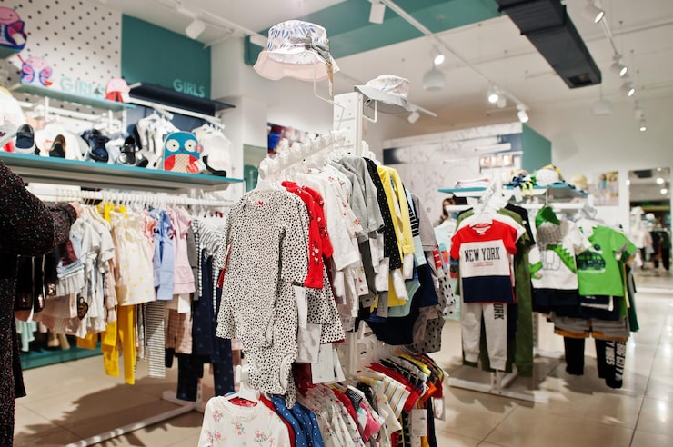 Gratis Foto lichte kinderkleding hangt aan het display in de babykledingwinkel