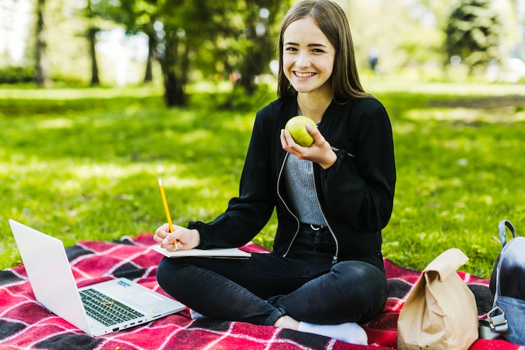 Gratis Foto meisje studeren en eten van een appel