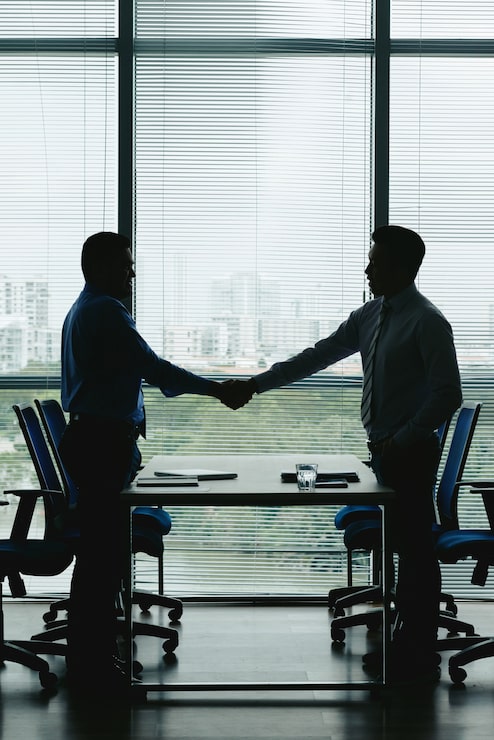 Gratis Foto overzichten van twee zakenmensen die handen schudden om de win-win deal te vieren