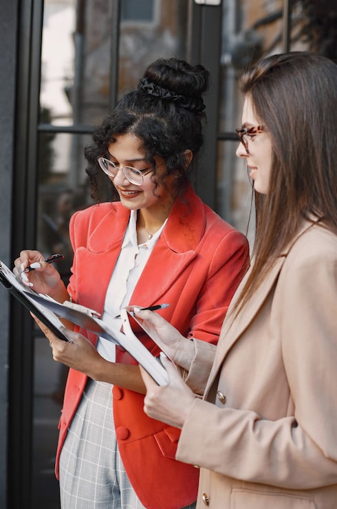 Gratis Foto vrouwelijke collega's bespreken gegevens in het café buiten. multiraciale vrouwelijke personen die productieve strategie analyseren voor zakelijke projectie met behulp van documenten in straatcafé