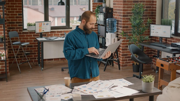 Gratis Foto zakenman voelt zich gelukkig over succesvolle projectwinst, leest nieuws op laptop. voltooide werknemer geniet van triomf en doel na ondertekening van contract, ambitieus over carrière