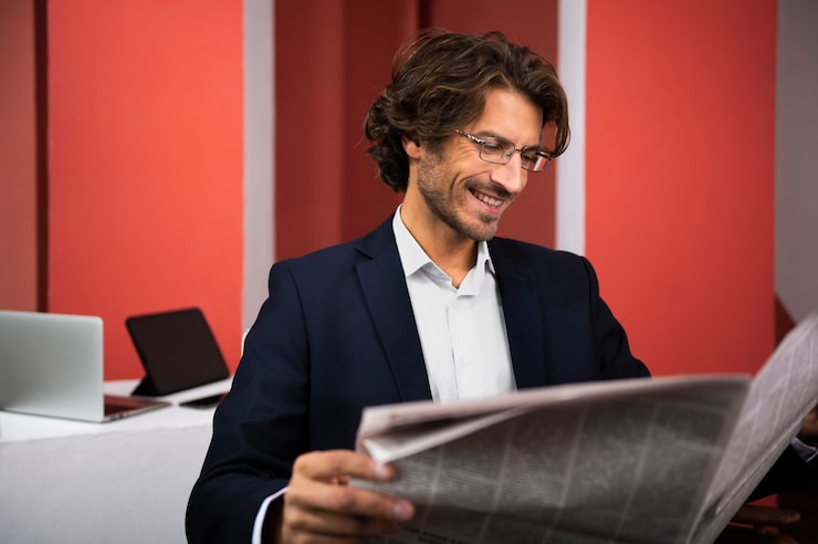 Gratis Foto zijaanzicht smiley man krant lezen
